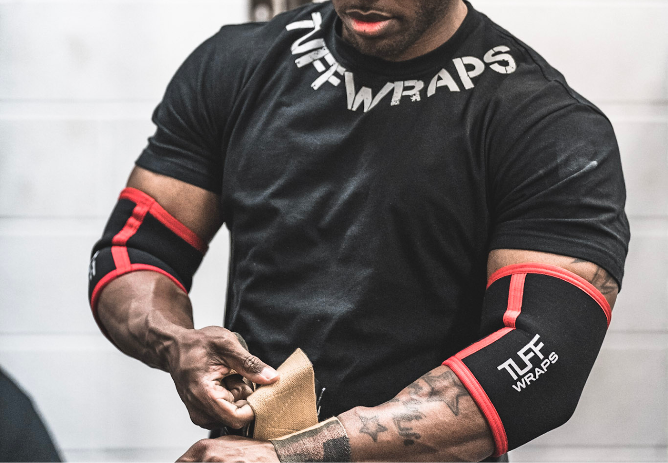 man putting on elbow wraps before bench press