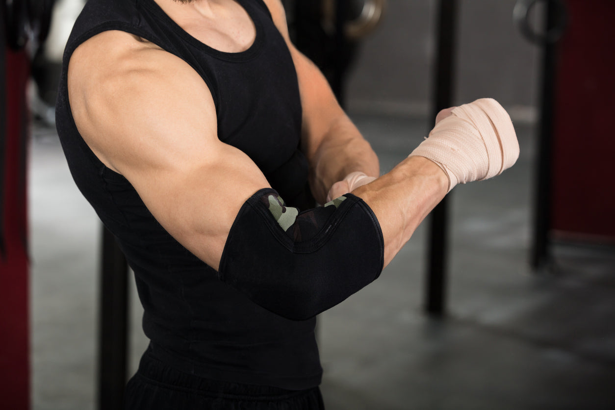 man putting on elbow wraps before bench press