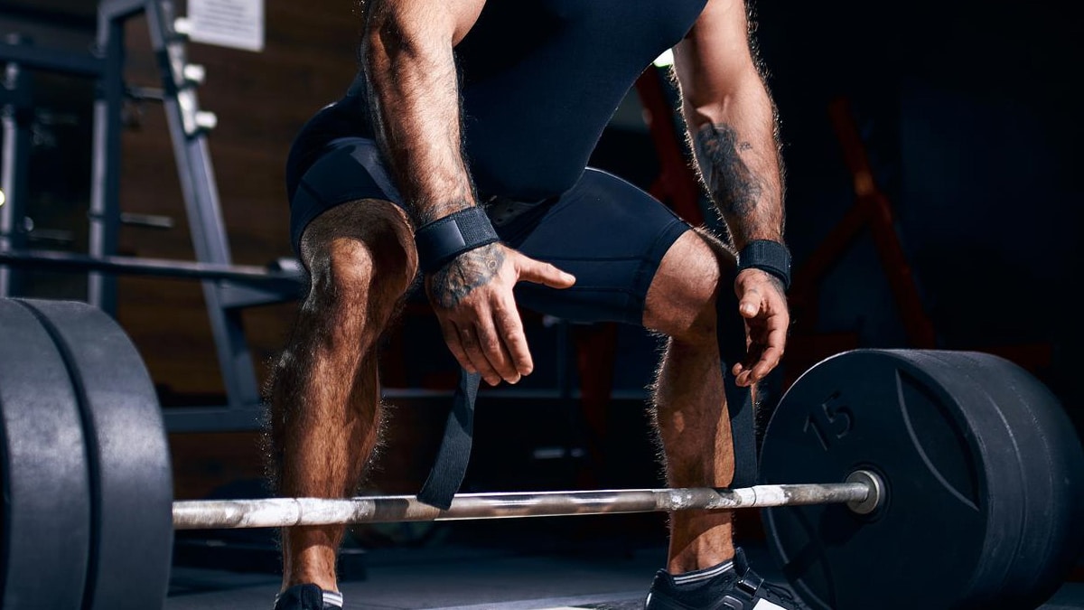 man using lifting straps for deadlift